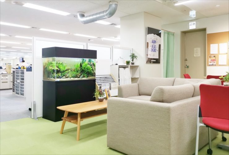 オフィス休憩室のソファ横に設置された大型水草水槽