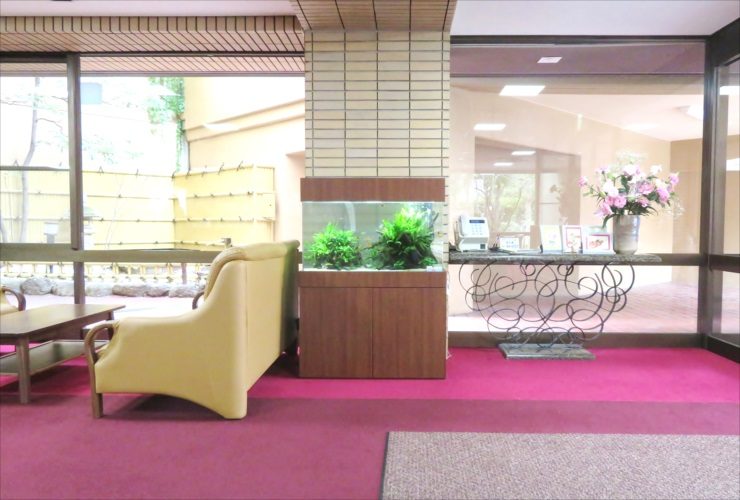 ロビーに設置された水草水槽とソファの風景
