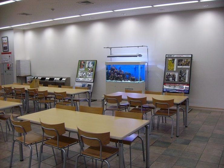 休憩スペースに設置された大型海水魚水槽とテーブル席