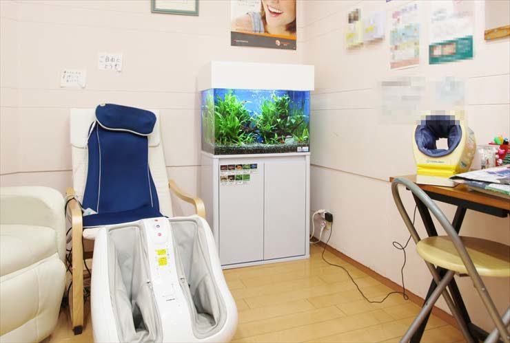 マッサージ機と水草水槽が設置された待合室の風景