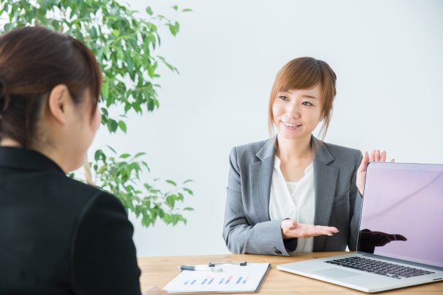 ノートパソコンを使い商談を行うスーツ姿の女性二人