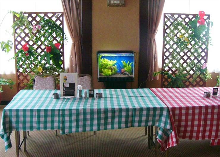 チェック柄テーブルと水草水槽のあるレストランの店内風景