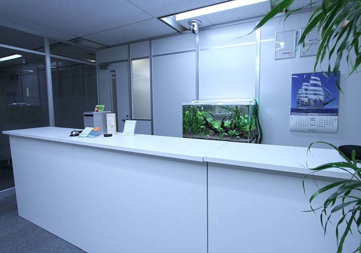 オフィスの白い受付カウンターに設置された水草水槽