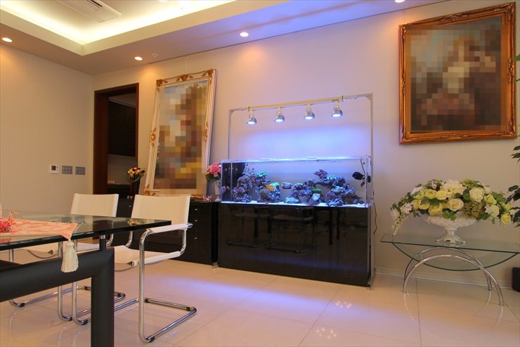 リビングに設置された大型の海水魚水槽と白いインテリア