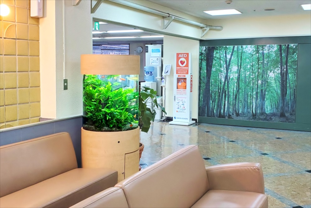 待合室に設置された円柱型水槽と水草のレイアウト