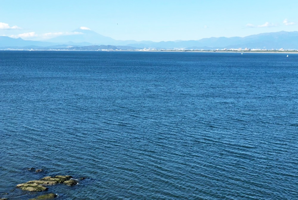 青い海と遠くに見える山並みや富士山の風景
