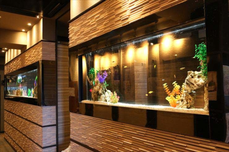 飲食店壁面に埋め込まれた大型の熱帯魚水槽と内装デザイン
