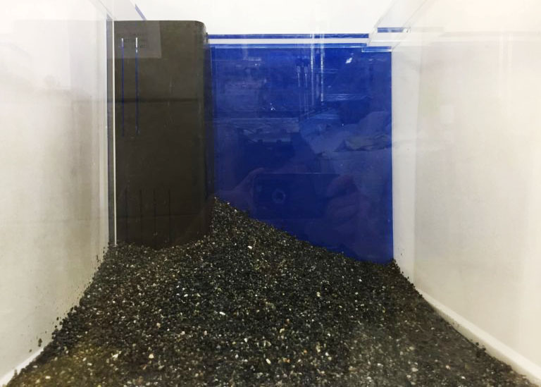 黒い底砂を敷いた青い背景の小型水槽と投げ込み式フィルター