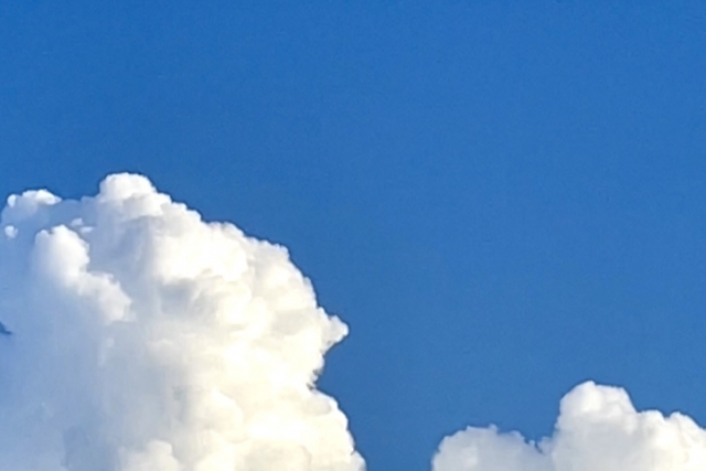 青い空に浮かぶ大きな白い入道雲と夏の空の風景