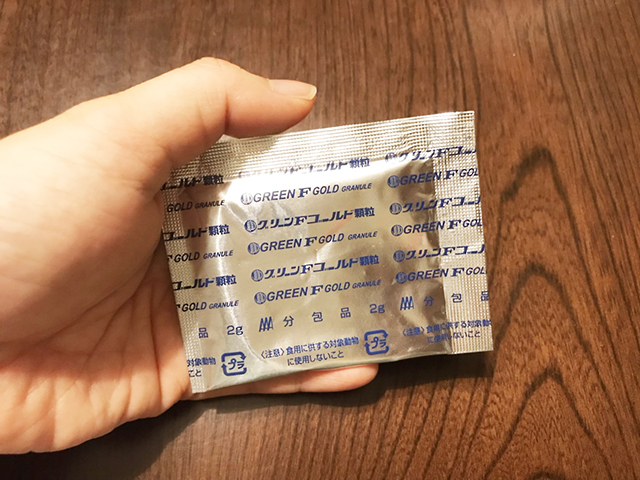 グリーンエフゴールド顆粒の分包を持つ手