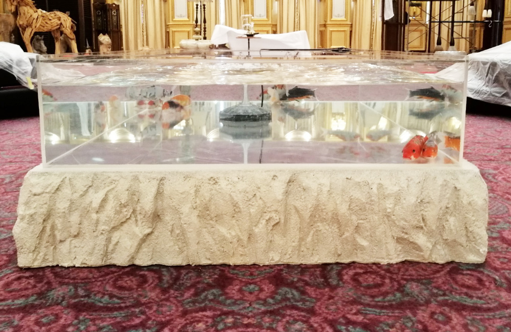 岩肌風の台座に設置された金魚が泳ぐ平型水槽