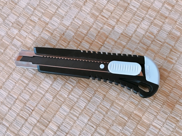 畳の上に置かれた黒とグレーのカッターナイフ