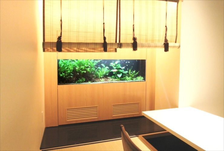 和室の壁に埋め込まれた大型の水草水槽と御簾