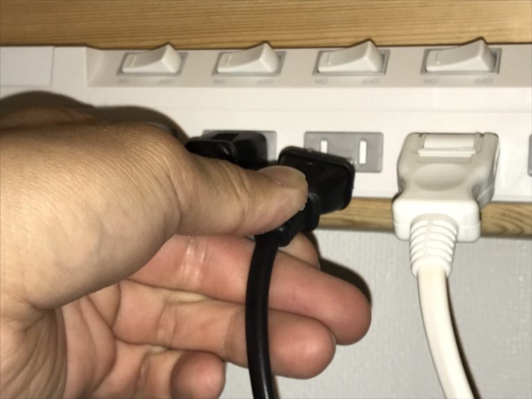 電源タップに黒いコンセントプラグを差し込む手元