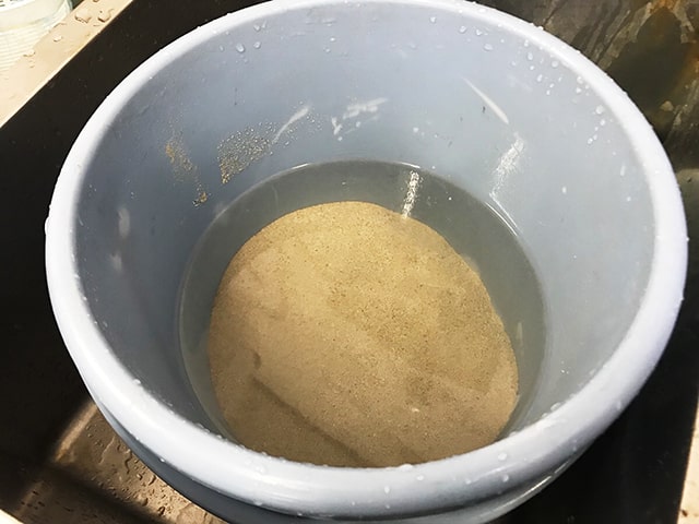 バケツに入れた水と底砂の洗浄風景