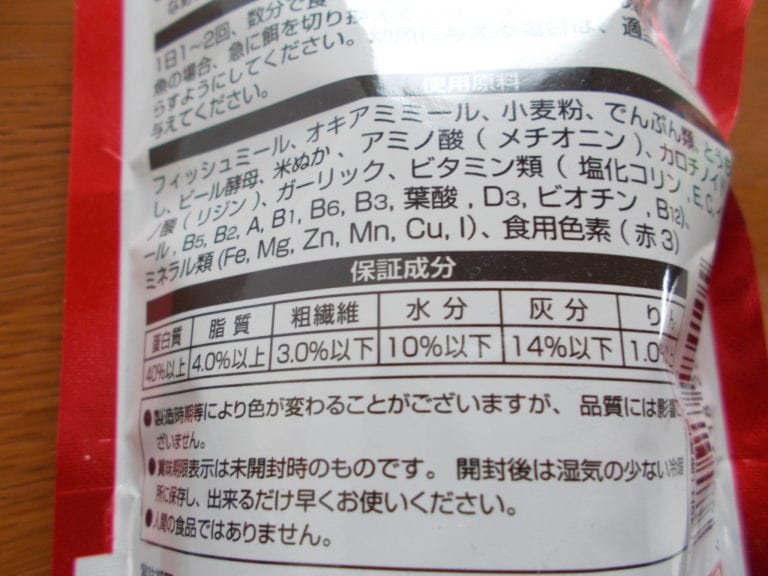 魚の餌のパッケージ裏面に記載された原材料と保証成分表