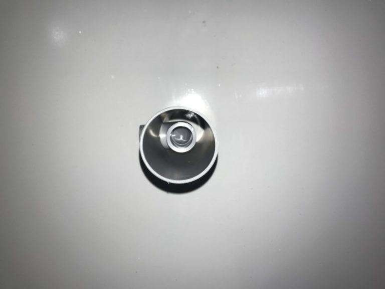 白い壁面に設置された円筒状の照明器具の正面画像