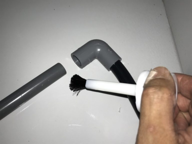 塩ビパイプの接続部に接着剤を塗る手元のアップ