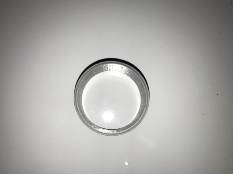 白い平面に置かれた円形のプラスチック製容器の蓋