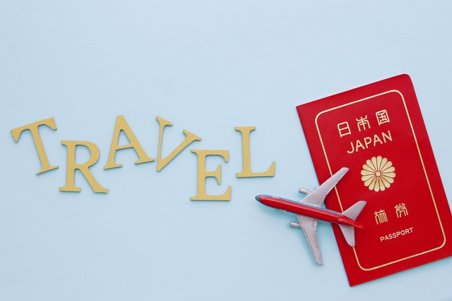 TRAVELの文字と日本のパスポートと飛行機の模型