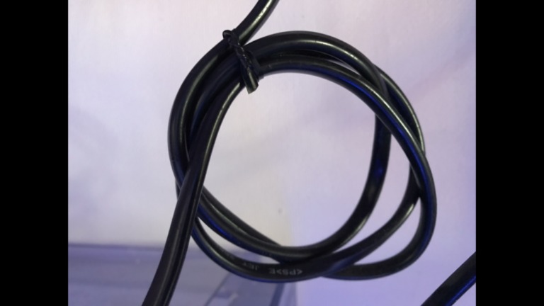 結束バンドで丸くまとめられた黒い電源コードの束