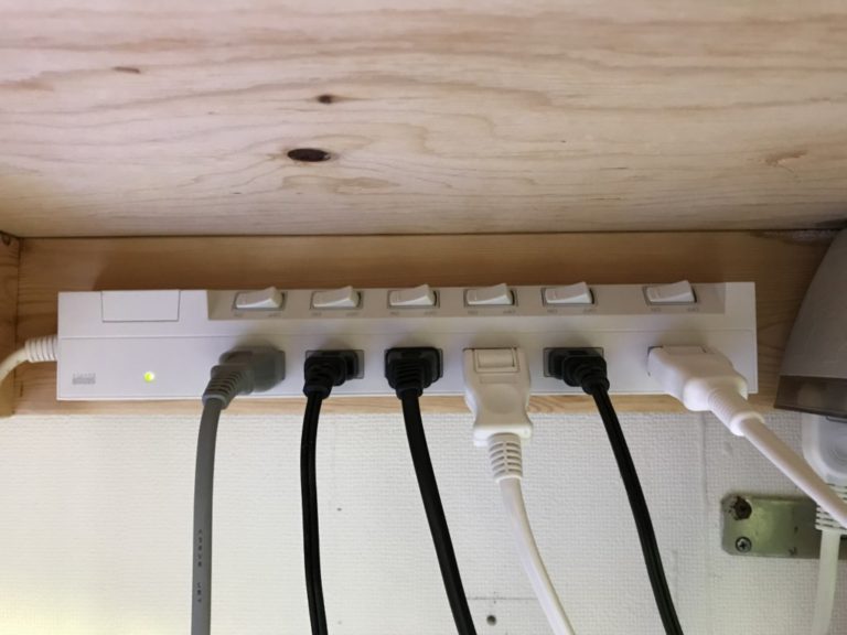 水槽台の裏側に固定された個別スイッチ付き電源タップ