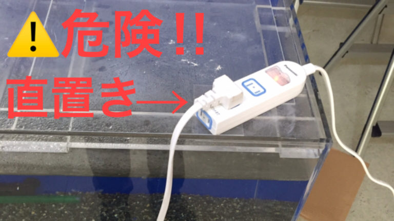 危険！！直置きと書かれた水槽蓋上の電源タップ画像