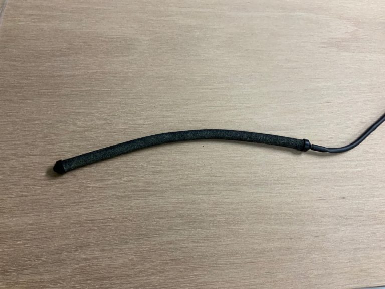 木目調の台に置かれた黒い棒状のエアーカーテン用ストーン