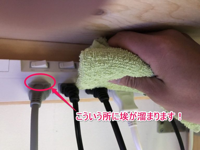 電源タップの埃が溜まる箇所を布で掃除する手元