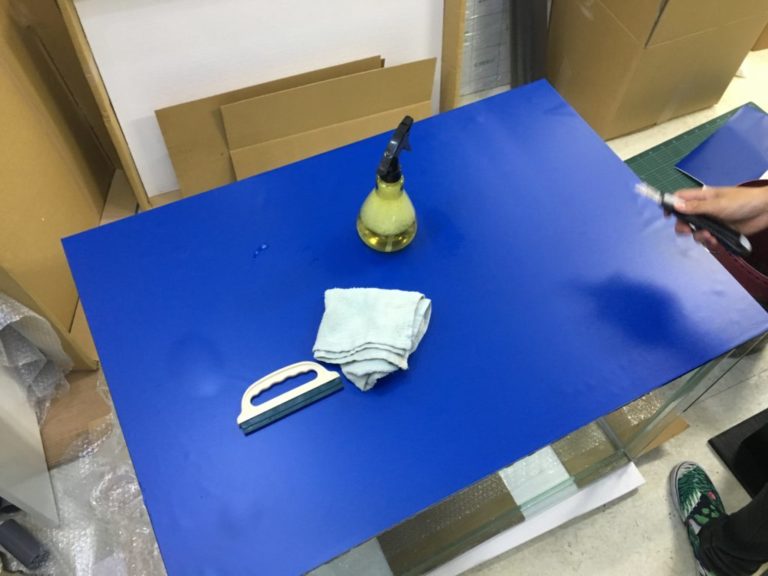 青いバックスクリーンと霧吹きやヘラなどの貼り付け道具