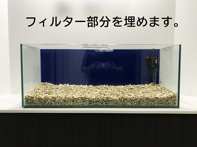フィルター部分を埋めますの文字と底砂を敷いた水槽