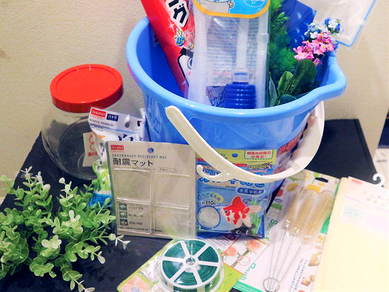 青いバケツに入った掃除用ポンプや耐震マット等の飼育用品