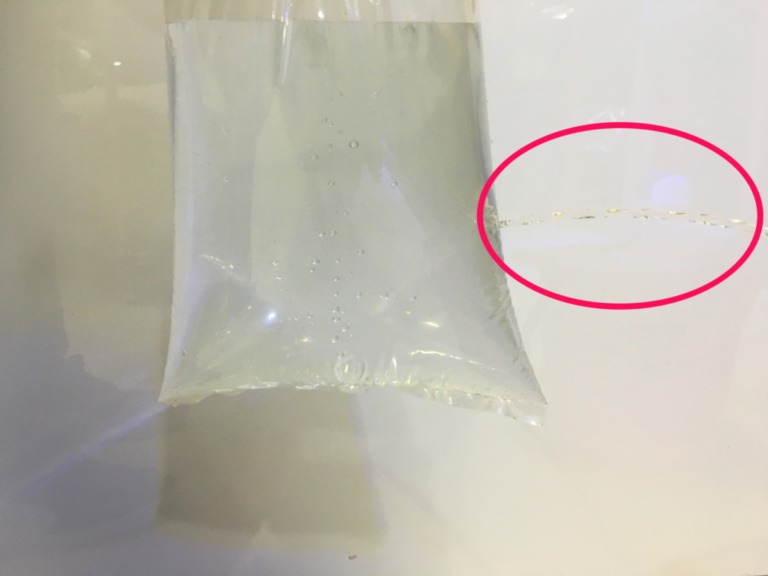 パッキング袋の傷を強調する赤い丸囲みの加工画像