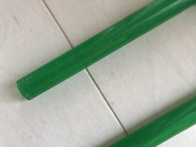 白い床の上に置かれた2本の緑色の外部フィルター用ホース