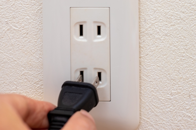 壁のコンセントに電源プラグを差し込む手元のアップ