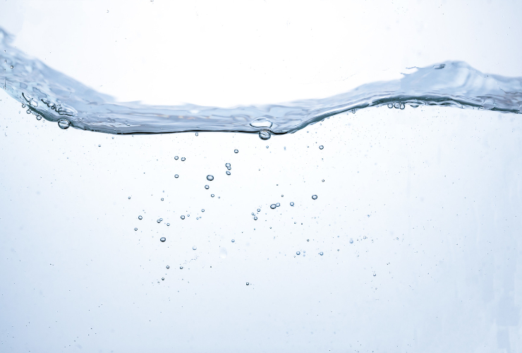 白背景に波打つ水面と水中を浮遊する気泡のイメージ画像