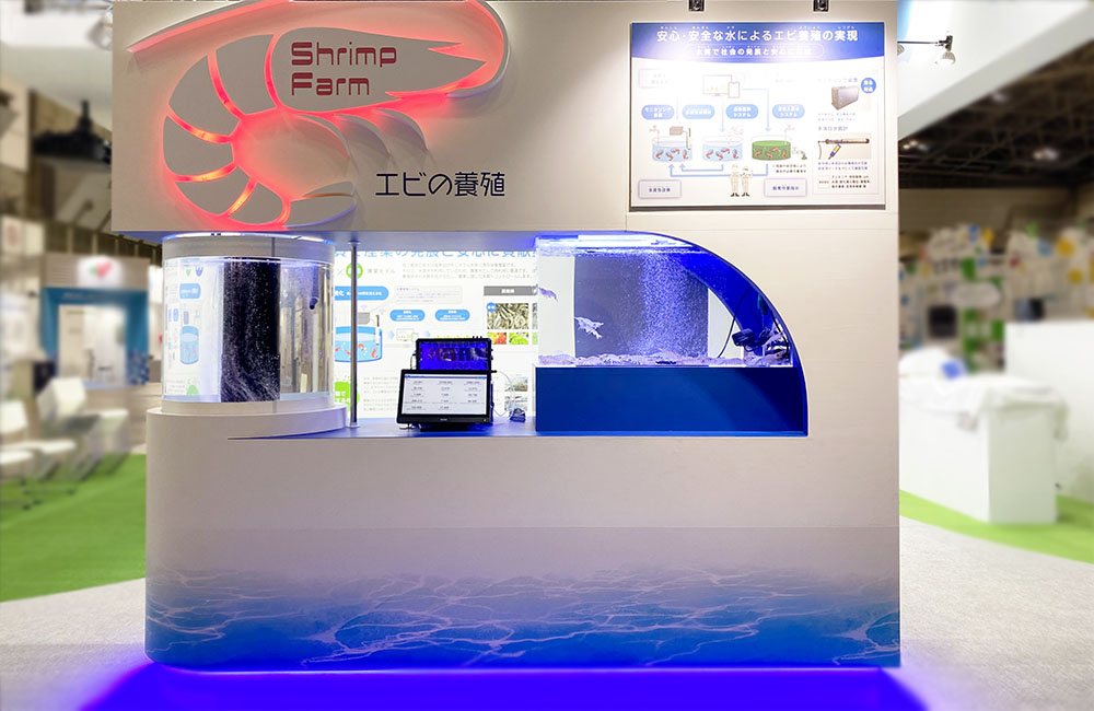 エビの養殖と書かれた看板がある展示ブースの水槽設備