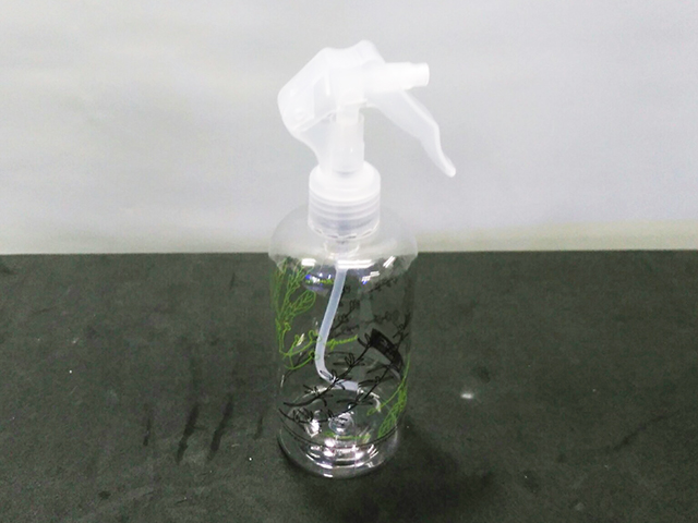 黒い台の上に置かれた透明なプラスチック製の霧吹きボトル
