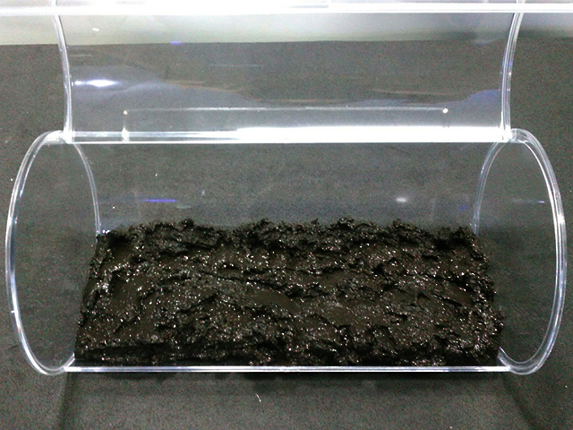 透明な円筒容器の底に敷かれた黒いソイル
