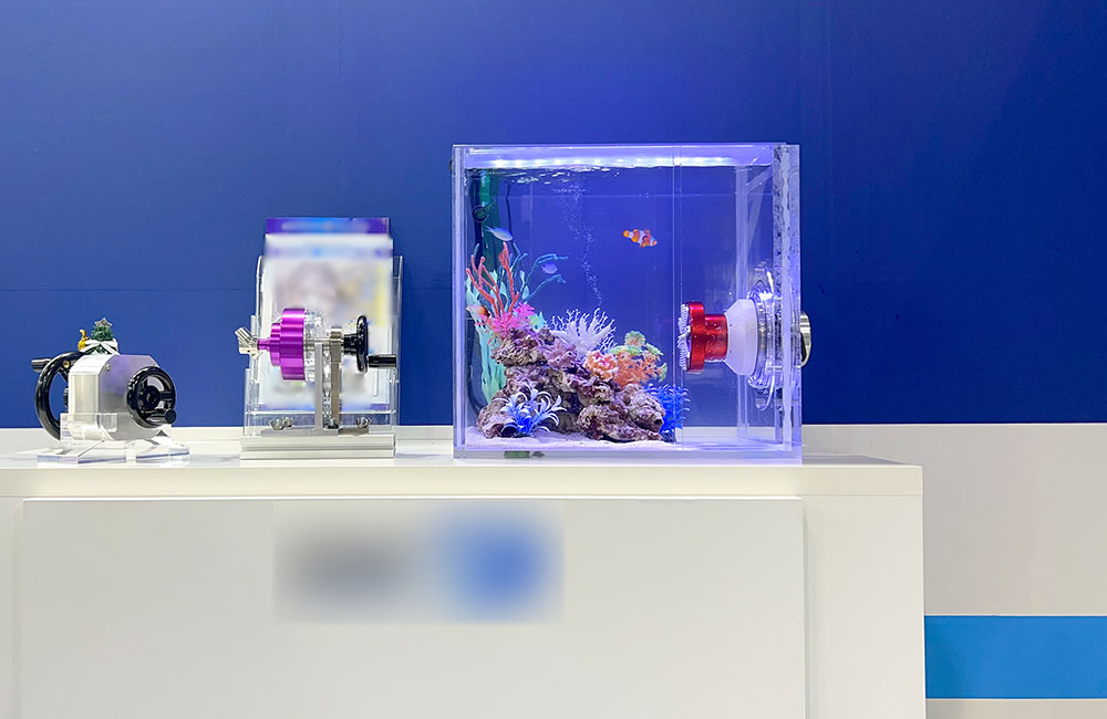青い壁を背景に設置された小型の海水魚水槽と展示用機材