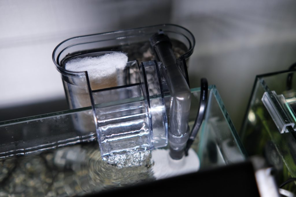 水槽の縁に設置された外掛け式フィルターと排水の波紋