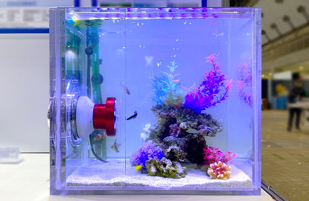 青い照明の小型水槽と人工水草や岩のレイアウト