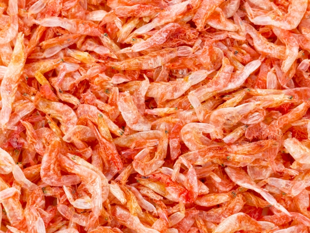 乾燥した赤色の小型エビが密集する観賞魚用の餌