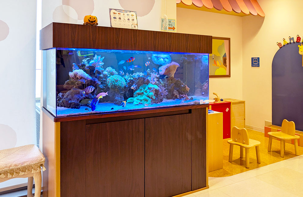 キッズルームに設置された大型海水魚水槽と子供用椅子
