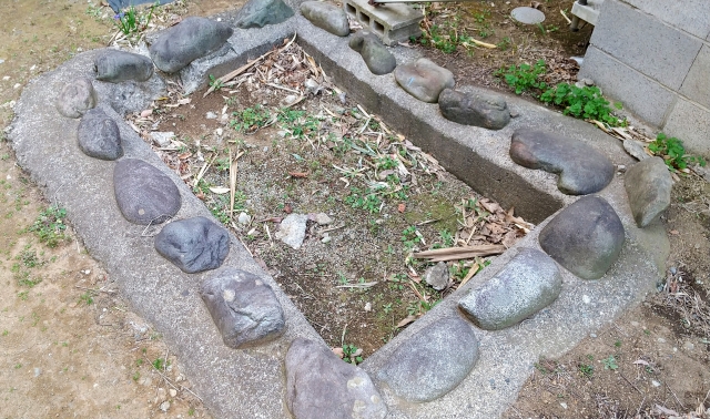 石で縁取られたコンクリート製の空の池の跡地