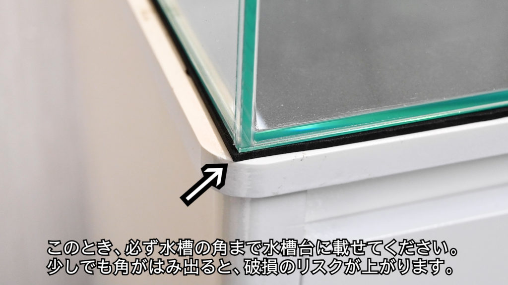 水槽の角を水槽台に載せる注意喚起の解説画像
