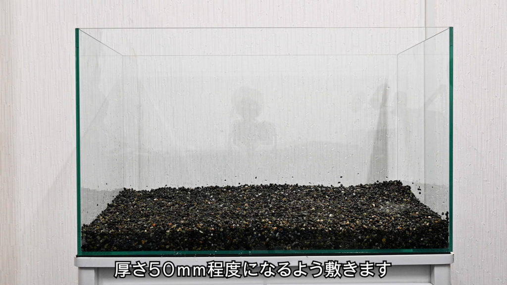 厚さ50mm程度に砂利を敷いた空の水槽の解説画像