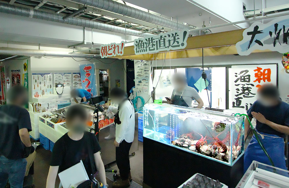 朝どれ漁港直送の看板と伊勢海老が入った活魚水槽