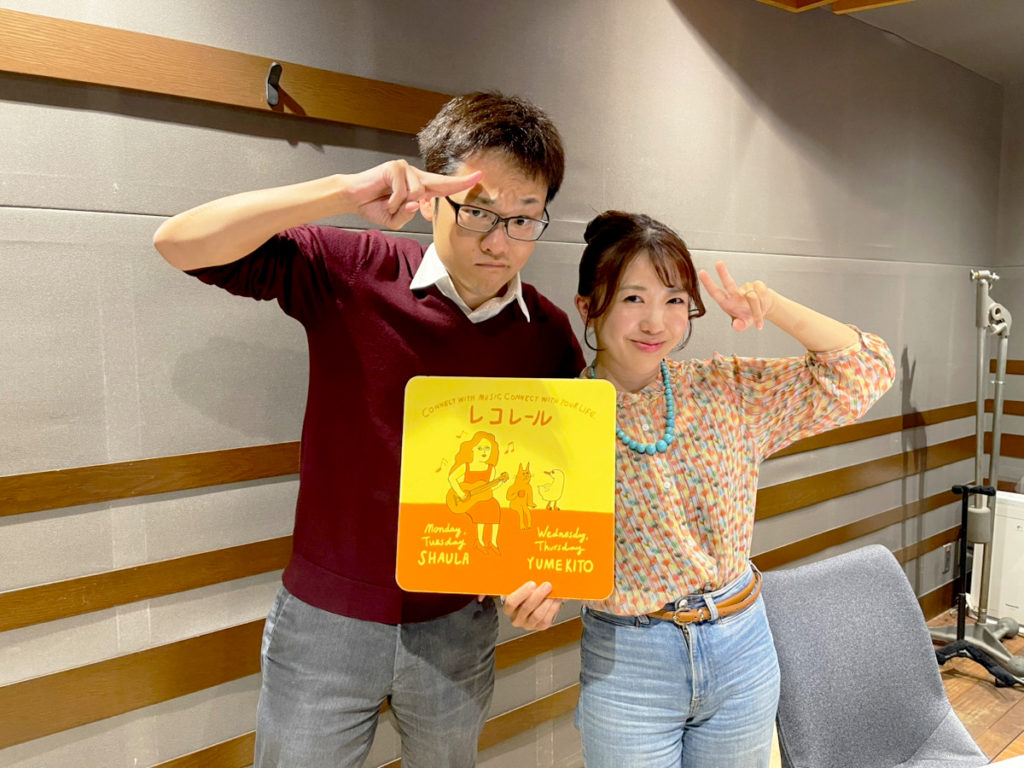 レコレールのパネルを持つ男女2人のスタジオ写真
