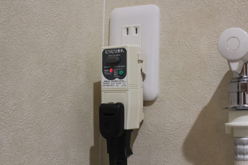 コンセントに差し込まれたビリビリガードと電源プラグ